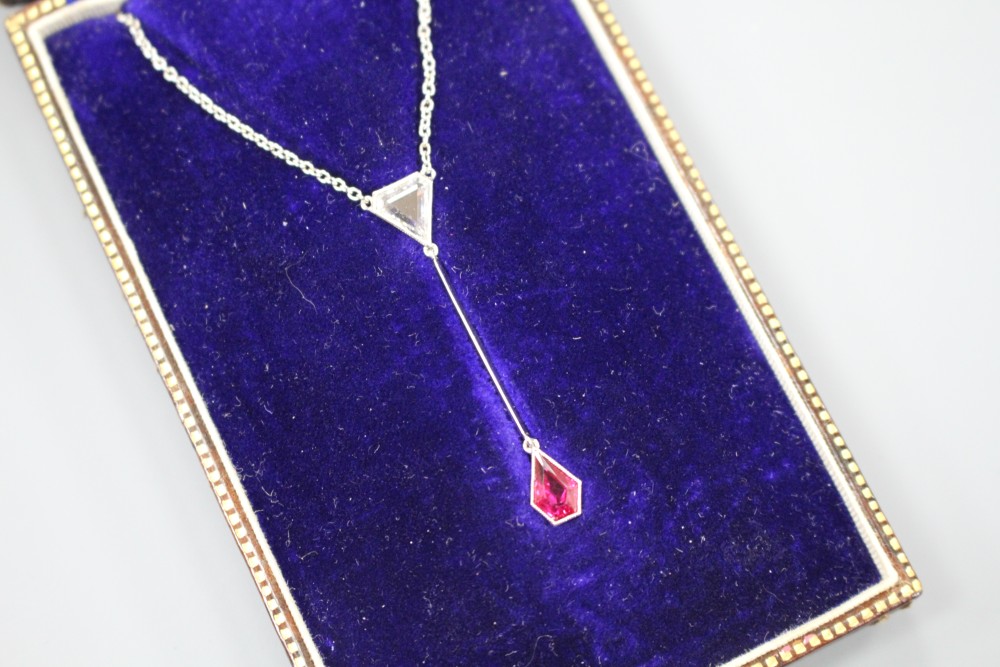 An Art Deco style white metal, ruby and diamond set drop pendant necklace, pendant section 40mm, gross weight 3.9 grams.